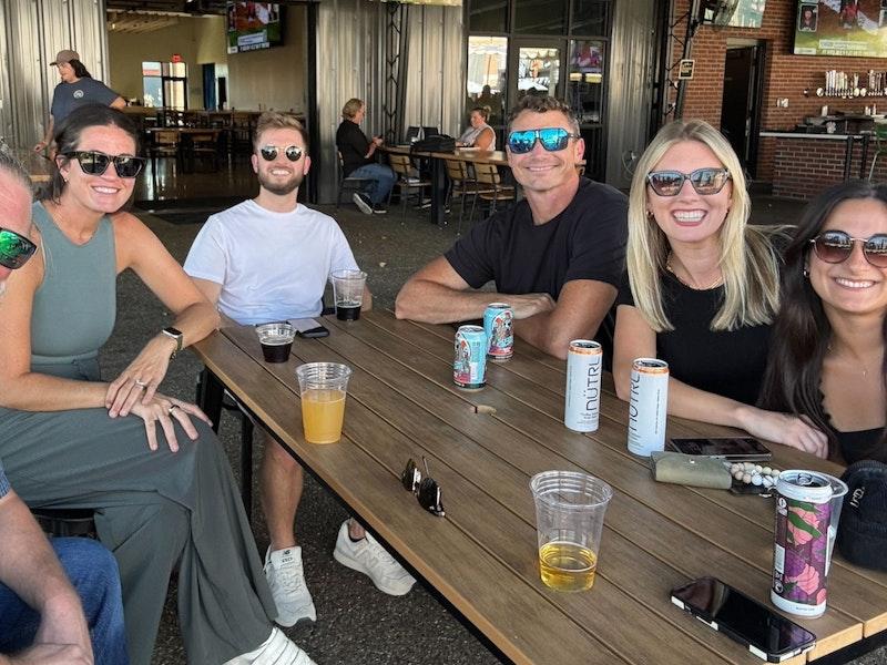 Ample team members around a table at an outdoor bar